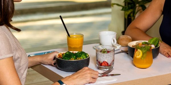 Two woman eating tasty chicken salads with dessert